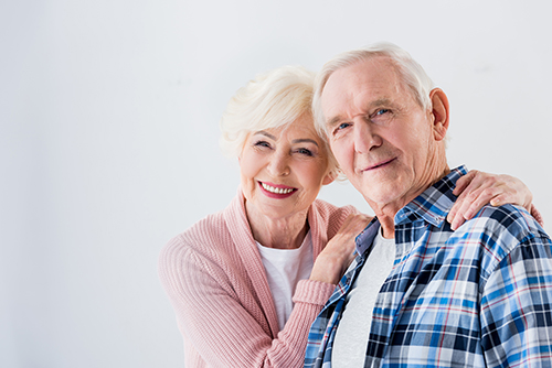 Senior Caucasian couple smiling with a white background