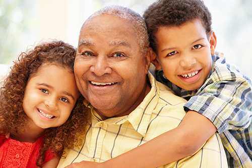 Senior african american man embracing his two young grandchildren